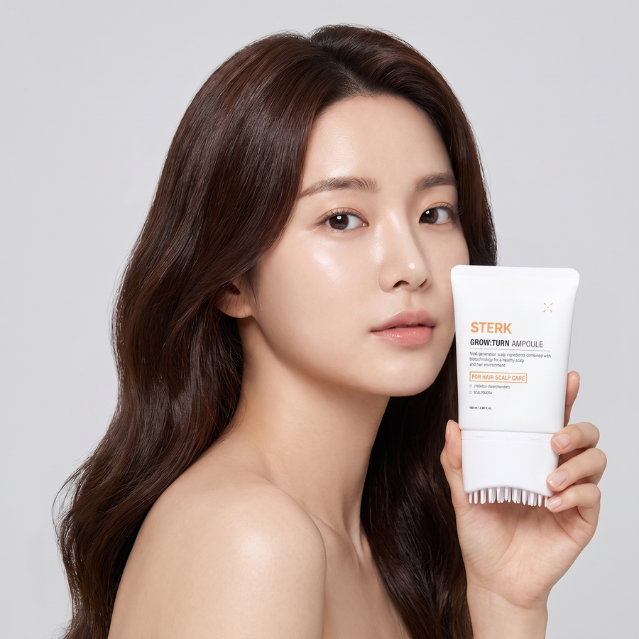 Woman holding STERK GrowTurn hair brush serum
